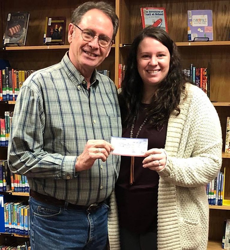 Eston gives a check to teacher