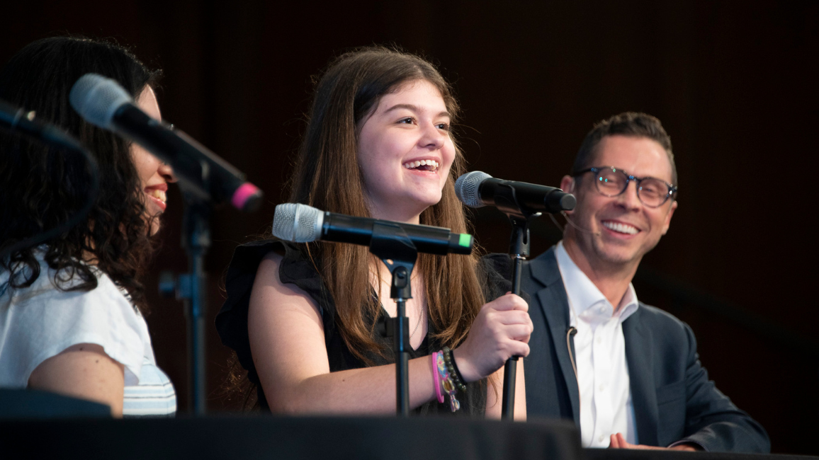 High-school aged girl speaks into microphone