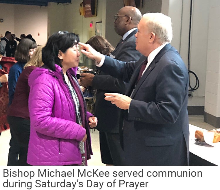 Bishop McKee helps with communion
