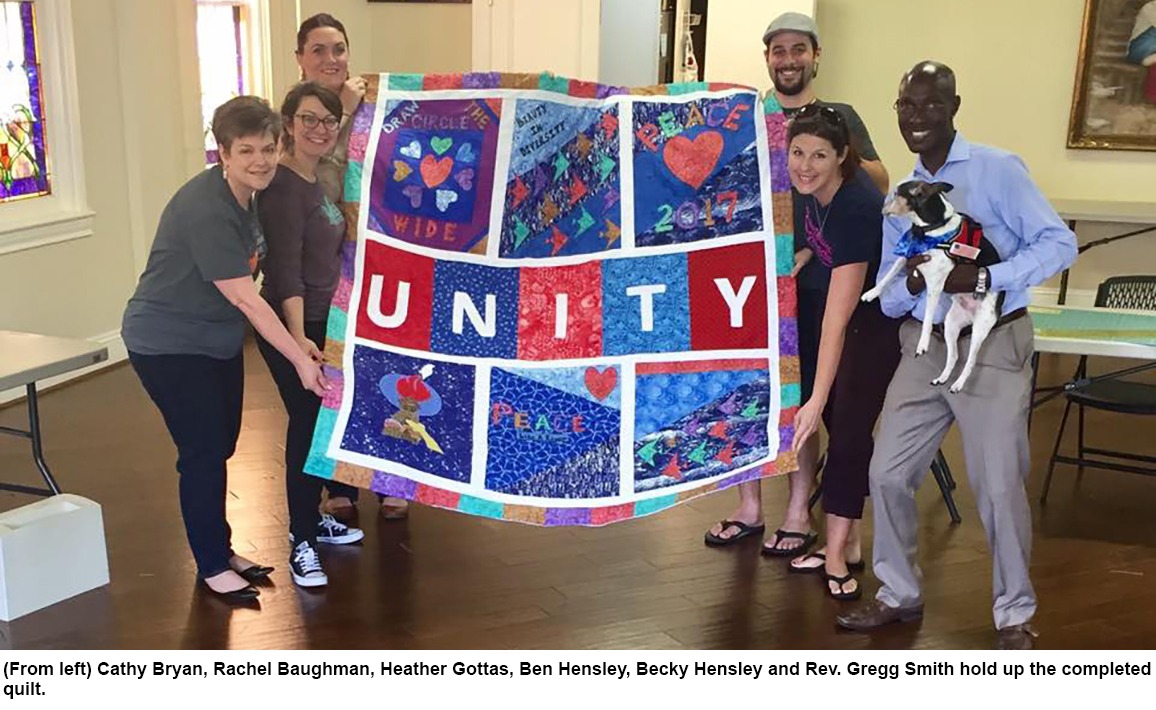 From left: Cathy Bryan, Rachel Baughman, Heather Gottas, Ben Hensley, Becky Hensley, and Rev. Gregg Smith hold up the completed quilt.