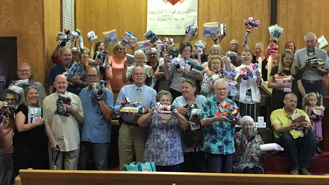 Church members hold up their donations